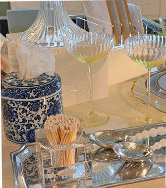 A Fitzgerald’s tablescape: coupe glasses, a blue-and-white chinoiserie tissue box and silver trays
